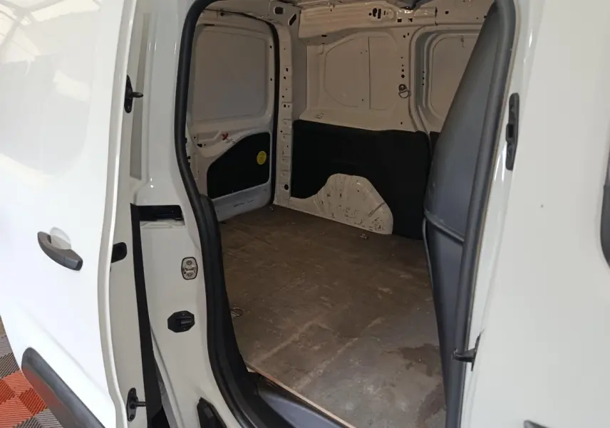 Vue intérieure de la partie arrière ouverte d’un Citroën Berlingo blanc 2021, montrant l’espace de chargement vide.