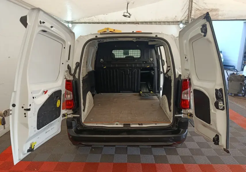Vue arrière du Citroën Berlingo blanc 2021 avec portes ouvertes montrant l'espace de chargement vide et la cloison de séparation.