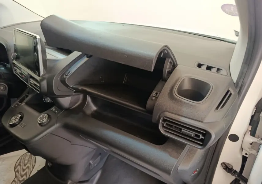 Intérieur du Citroën Berlingo 2021 blanc, vue côté passager montrant la boîte à gants ouverte et la console centrale noire.