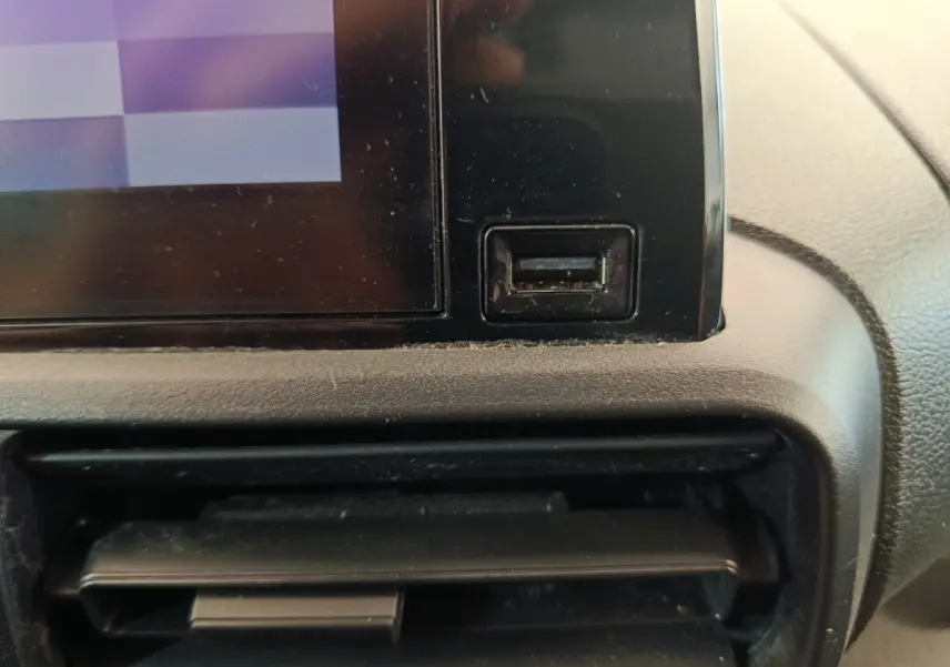 Détail de la console centrale du Citroën Berlingo 2021 montrant un port USB noir et une sortie d'air, intérieur gris.