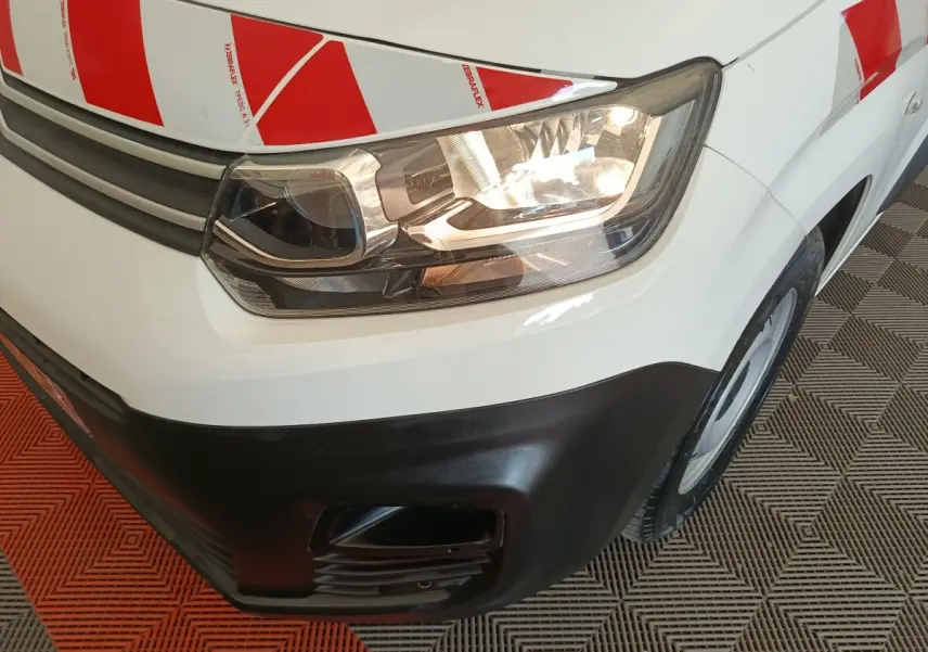 Gros plan sur l'avant droit blanc d'un Citroën Berlingo 2021 avec marquage rouge et blanc de sécurité.