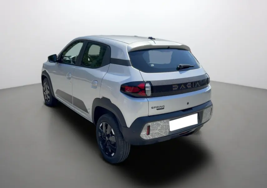 Vue 3/4 arrière droite d'une Dacia Spring gris éclair avec bande noire distinctive et jantes noires.
