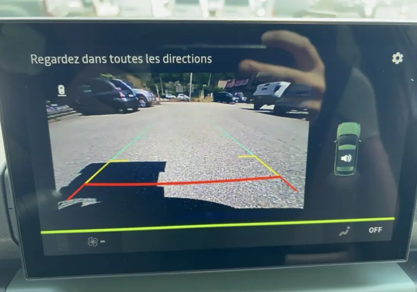 Écran de caméra de recul du Dacia Spring électrique 65 Extreme montrant la vue arrière avec lignes de guidage colorées.