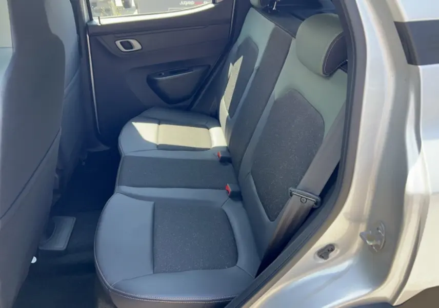 Vue intérieure des sièges arrière côté droit du Dacia Spring électrique gris éclair, sellerie cuir tissu bicolore.