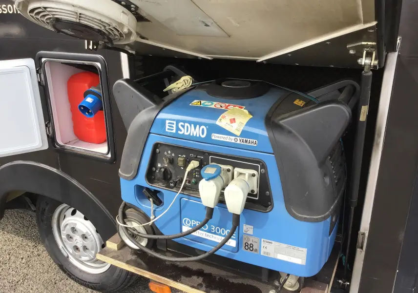 Gros plan sur groupe électrogène Yamaha bleu intégré côté gauche du Citroën Jumper gris Graphito 2017 food truck.