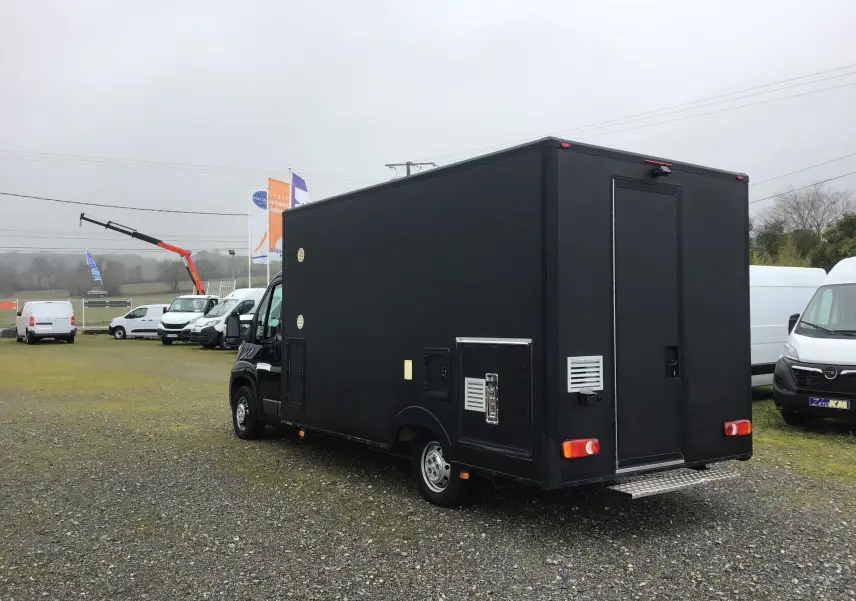 Vue 3/4 arrière droite d'un Citroën Jumper gris Graphito aménagé en food truck avec porte arrière et rangements latéraux.