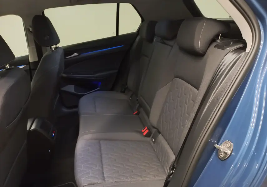 Vue intérieure côté droit montrant la banquette arrière en tissu gris de la Volkswagen Golf Bleu Anemone 2025.