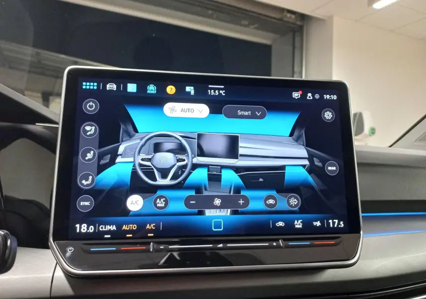 Écran tactile central affichant la commande de climatisation et le tableau de bord numérique de la Volkswagen Golf 2025.