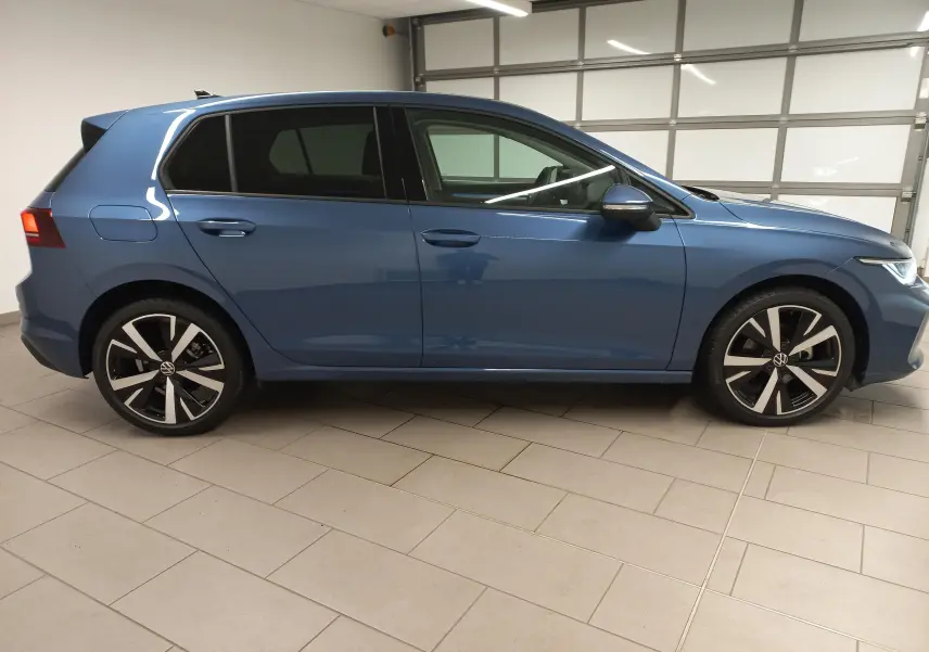 Volkswagen Golf 1.5 TSI 2025 en bleu Anemone, vue profil côté gauche avec jantes alliage 18 pouces Catania.