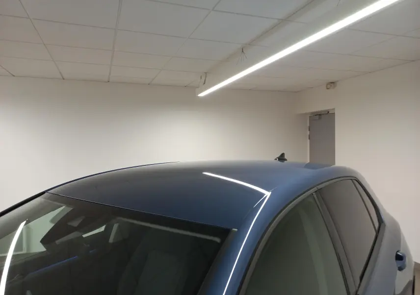 Vue en plongée du toit et des vitres teintées d'une Volkswagen Golf 1.5 TSI Bleu Anemone dans un intérieur blanc.