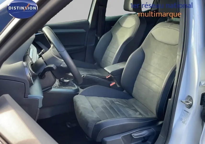 Vue intérieure côté conducteur du SEAT Arona blanc, mettant en valeur les sièges en cuir et alcantara gris foncé.