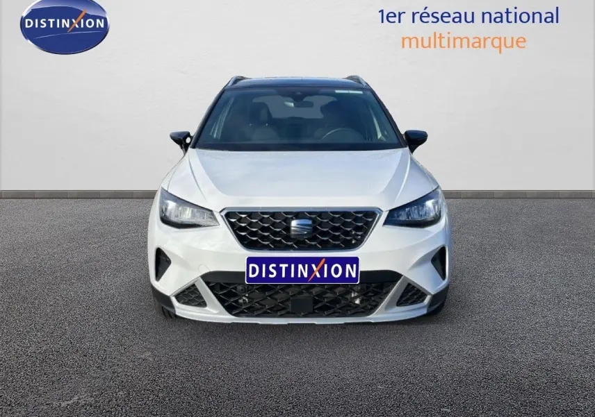 Vue frontale d'un SEAT Arona blanc avec toit noir, mettant en valeur sa calandre et ses phares LED.