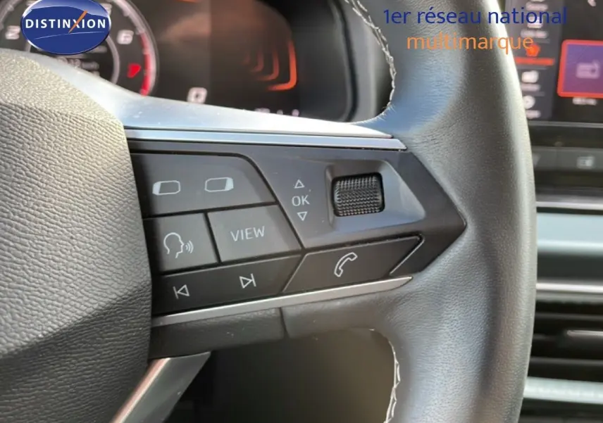 Gros plan sur le volant multifonction noir du SEAT Arona 2025, avec commandes audio et téléphone visibles.