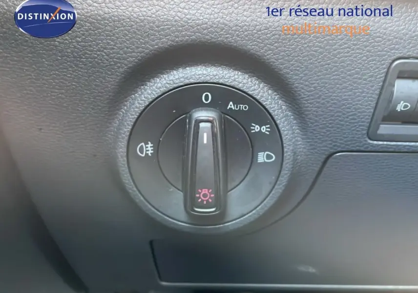 Gros plan sur la molette de commande des phares dans l’habitacle du SEAT Arona blanc toit noir, version 2025.