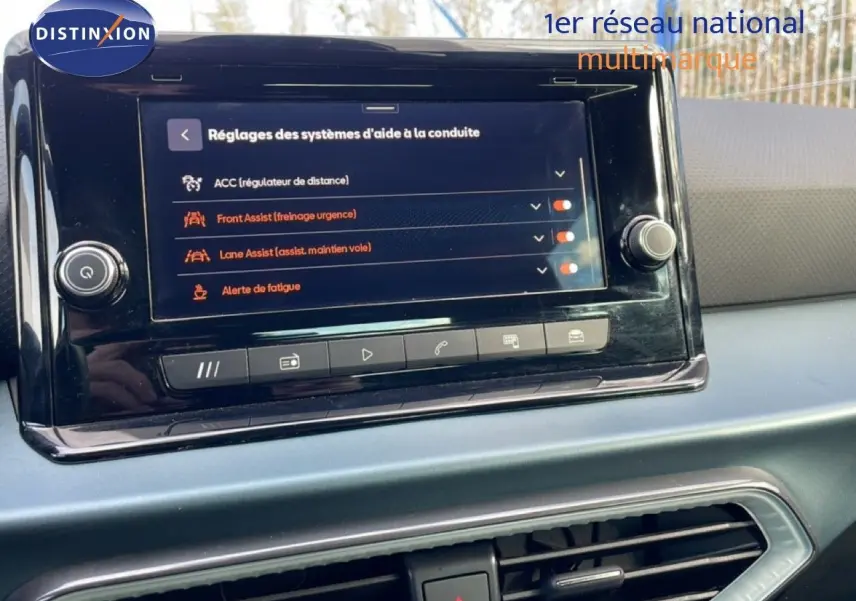 Écran tactile central affichant les réglages d’aide à la conduite dans l’habitacle du SEAT Arona blanc toit noir, vue de face.