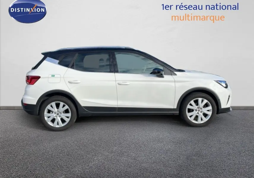 SEAT Arona blanc avec toit noir, vue profil droit, mettant en valeur ses jantes alliage et lignes dynamiques.