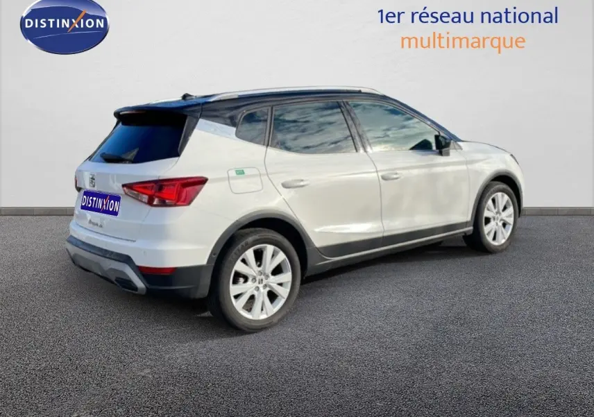 Vue 3/4 arrière droite d'un SEAT Arona blanc à toit noir, avec jantes alliage et vitres teintées.