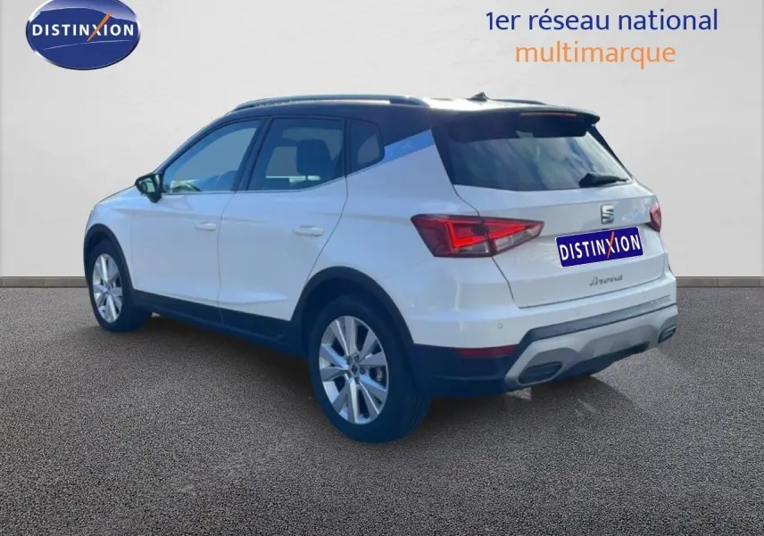Vue 3/4 arrière droite du SEAT Arona blanc avec toit noir, jantes alliage et détails de carrosserie noirs.
