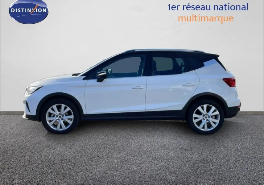 Vue de profil côté gauche d'un SEAT Arona blanc avec toit noir, jantes alliage et lignes épurées.