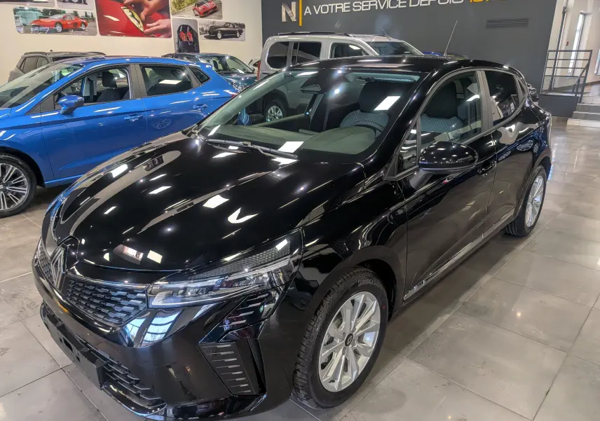 Renault Clio V noire vue en 3/4 avant droit dans un showroom, avec jantes argentées et phares LED distinctifs.