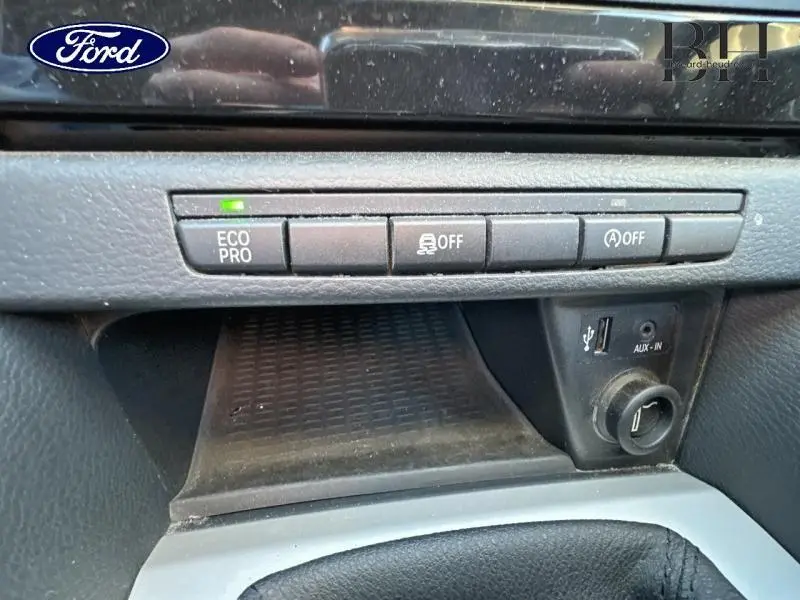 Vue rapprochée du tableau de bord BMW X1 Mineralgrau 2013, montrant les boutons Eco Pro, contrôle de stabilité et arrêt auto du moteur.