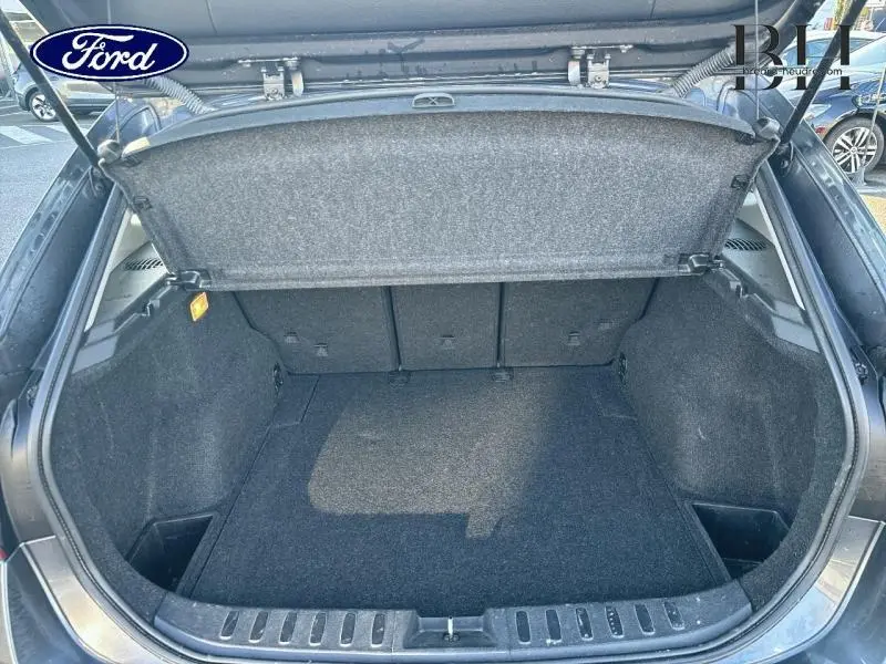 Coffre ouvert vu de l'arrière d'un BMW X1 Mineralgrau 2013, montrant l'espace de chargement et la tablette cache-bagages.