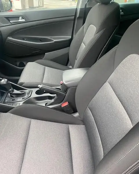 Vue intérieure côté droit du Hyundai Tucson 2019, sièges tissu gris et console centrale avec boîte automatique.