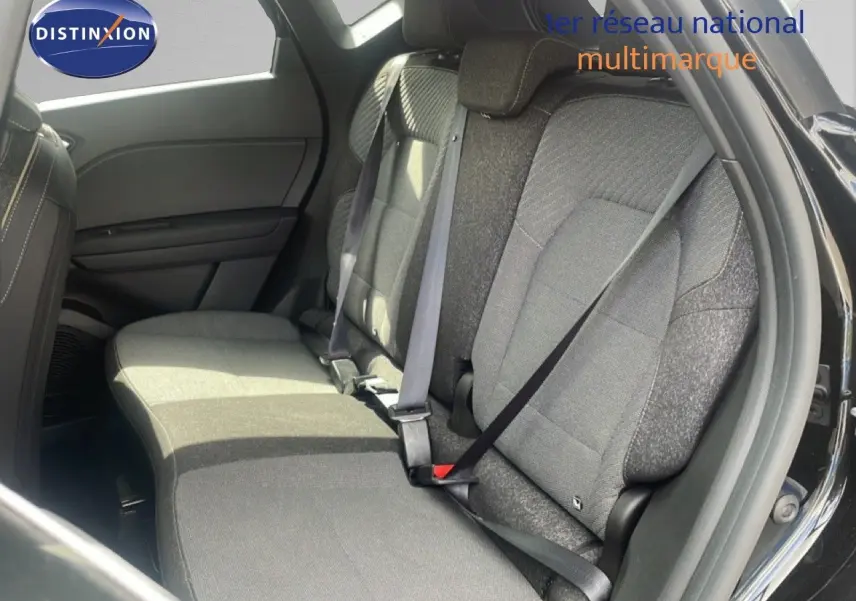 Vue intérieure côté droit des sièges arrière en tissu gris du Renault Captur noir étoile métal 2025 avec ceinture attachée.