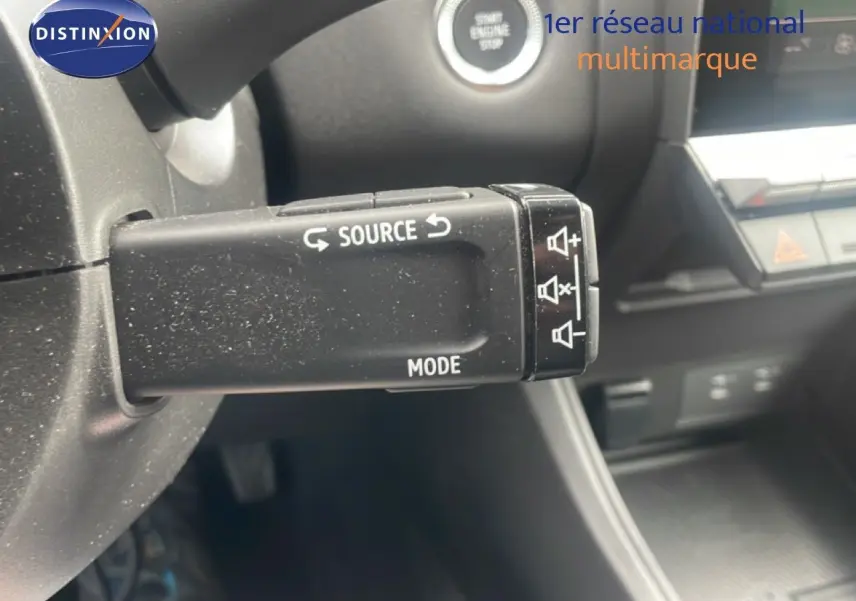 Gros plan sur la commande multimédia au volant d’un Renault Captur noir étoile métal avec intérieur gris noir.