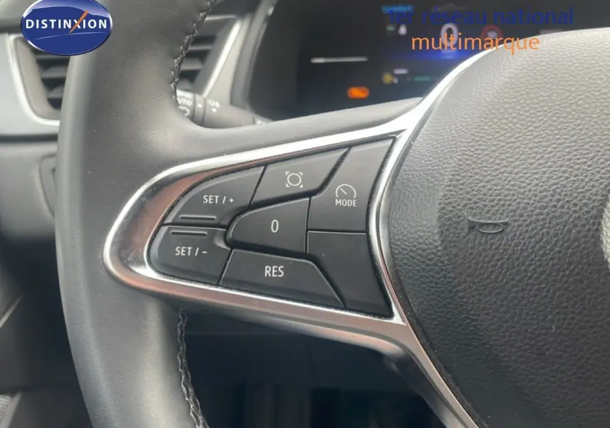 Gros plan sur le volant côté gauche du Renault Captur 2025, montrant les commandes de régulateur de vitesse et mode.