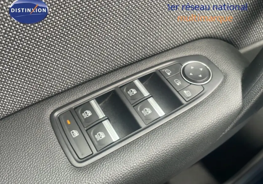 Gros plan sur la commande des vitres électriques côté conducteur du Renault Captur 2025, finition tissu gris noir.