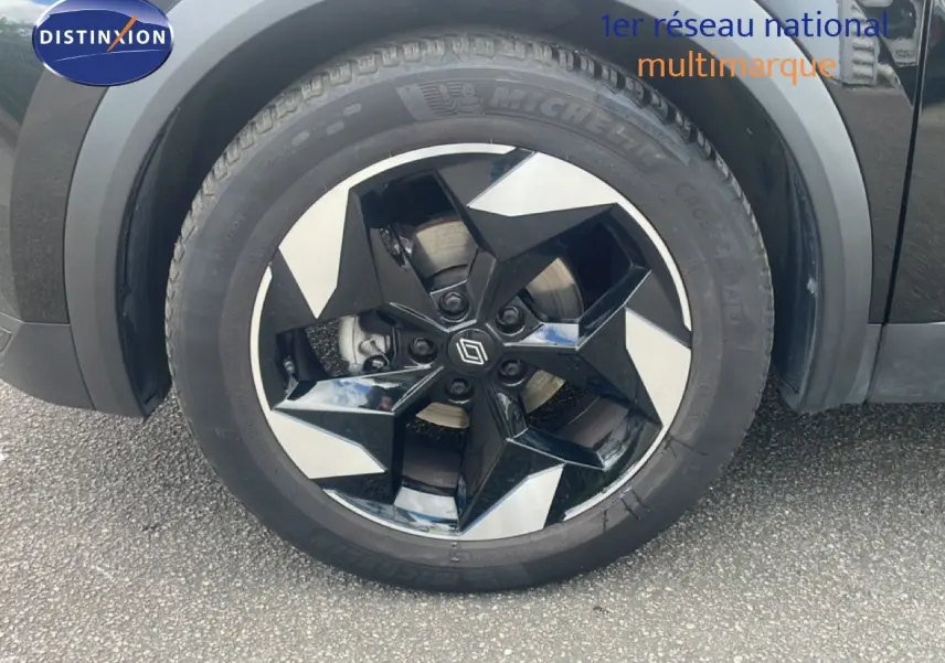 Gros plan sur la roue avant gauche du Renault Captur noir étoile métal avec jante biton au design géométrique.