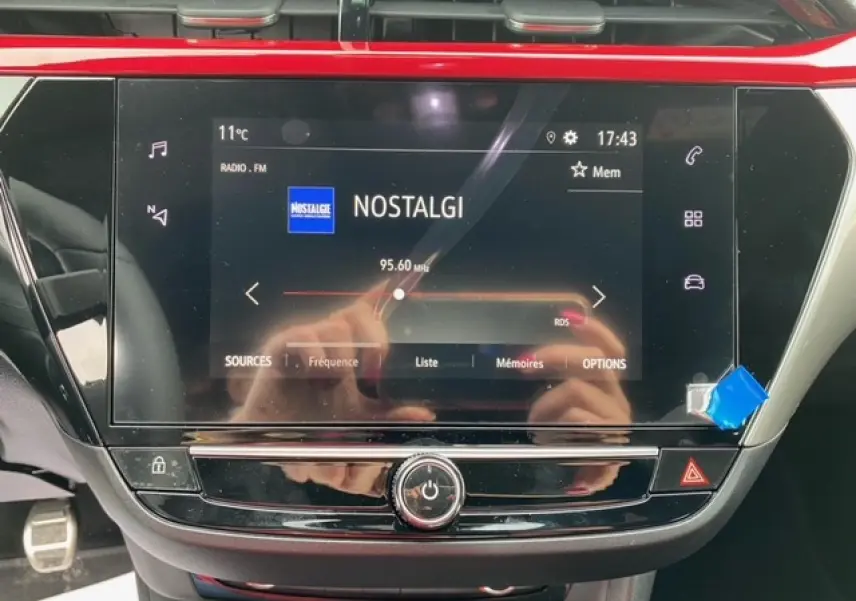 Écran tactile central de l’Opel Corsa 2022 affichant la radio FM, entouré de détails en noir et rouge intérieur.