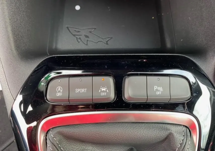 Gros plan sur les boutons de commande du mode Sport et aides à la conduite dans une Opel Corsa gris magnetic 2022.