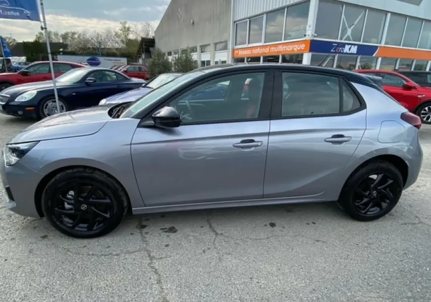 Vue de profil côté gauche d’une Opel Corsa gris magnetic avec toit noir et jantes alliage noires brillantes.