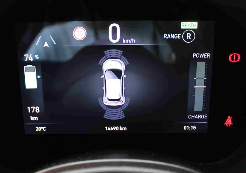Affichage numérique du tableau de bord montrant la Fiat 500 électrique blanche vue de dessus avec autonomie et indicateurs de charge.