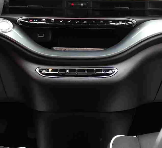 Vue intérieure centrée sur la console et l’écran tactile de la Fiat 500 électrique 2023, sièges noirs avec surpiqûres blanches.