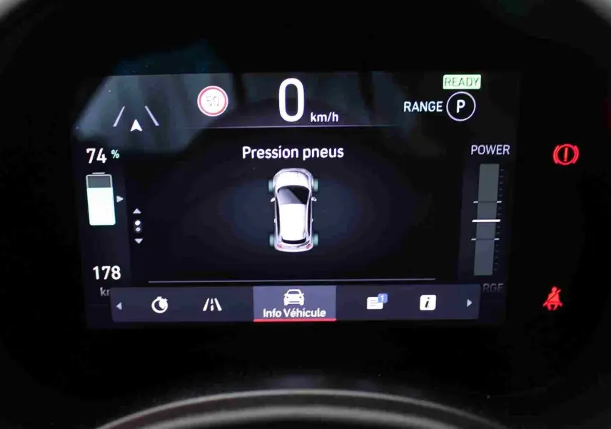 Affichage numérique du tableau de bord de la Fiat 500 électrique 2023 montrant la pression des pneus et l'autonomie à 74%.