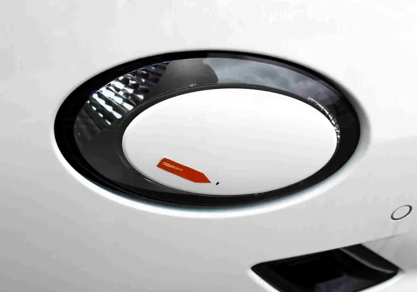 Gros plan sur la prise de recharge électrique blanche de la FIAT 500 électrique 2023, avec contour noir brillant.