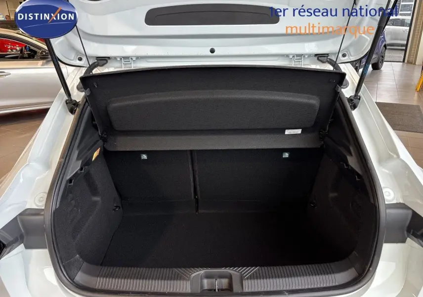Coffre ouvert vu de l'arrière d'une Renault Clio VI TCE 115ch Techno blanc glacier, intérieur noir spacieux.