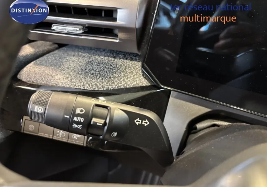 Gros plan intérieur sur la commande des feux et clignotants du tableau de bord de la Renault Clio VI TCe 115ch blanc glacier.