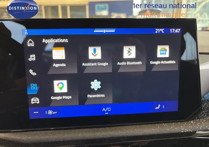 Écran tactile central de la Renault Clio VI blanc glacier, affichant les applications Google et la température intérieure.