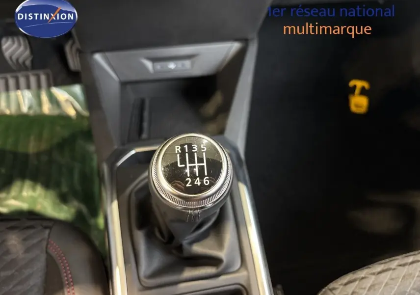 Gros plan sur le levier de vitesses manuel de la Renault Clio VI TCe 115ch Techno, intérieur noir avec surpiqûres rouges.