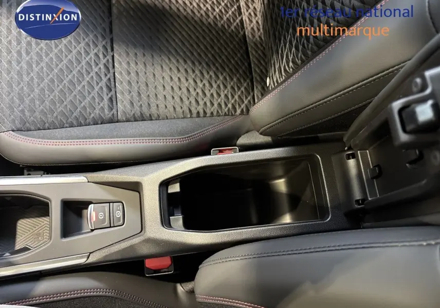 Vue rapprochée de la console centrale et des sièges en tissu noir avec surpiqûres rouges de la Renault Clio VI blanc glacier.