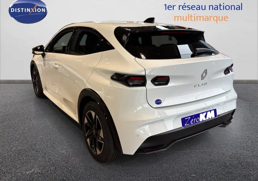 Vue 3/4 arrière droite d'une Renault Clio 6 blanche Glacier avec feux arrière LED et jantes noires.
