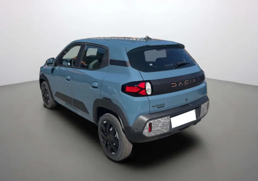 Vue 3/4 arrière droite d'une Dacia Spring électrique 65 Extrême bleu ardoise avec détails noirs et feux arrière LED.