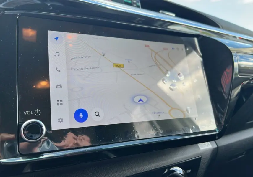 Écran tactile du système de navigation du Toyota Hilux 2025, affichant une carte routière avec commandes tactiles.