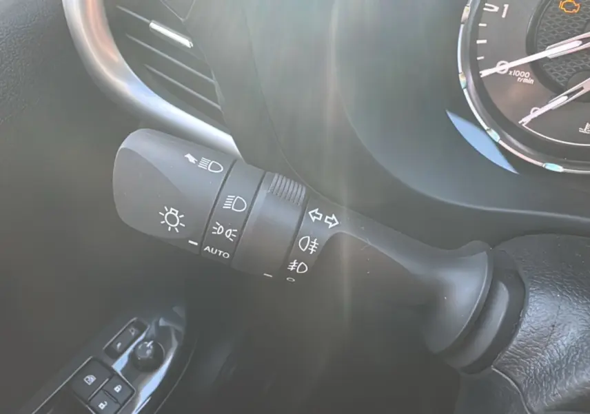 Gros plan sur la commande des phares et clignotants du Toyota Hilux 2025, finition Légende, intérieur noir.