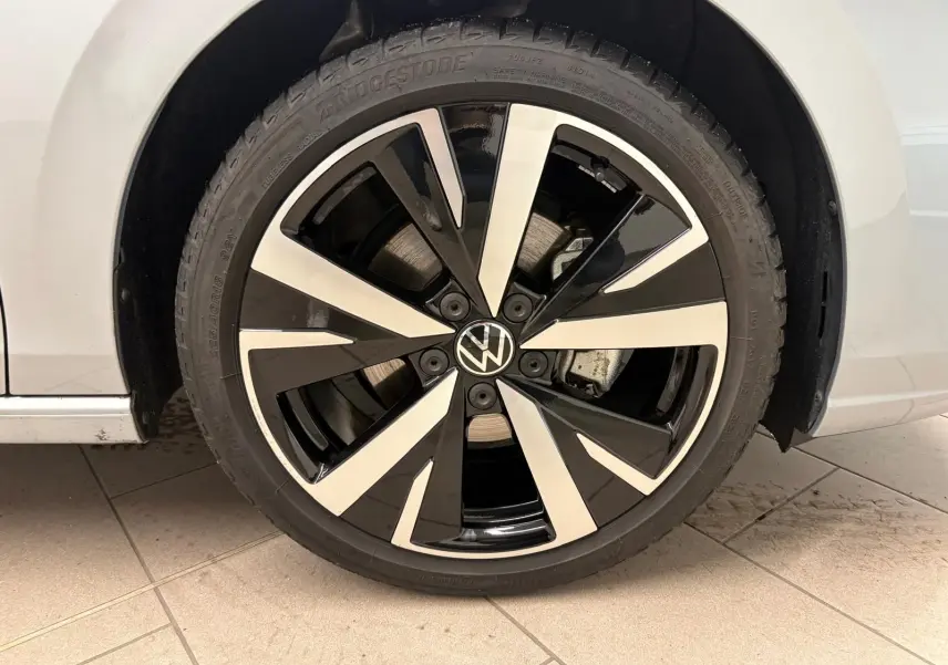 Gros plan sur la jante alliage 18'' Catania bicolore noir et argent de la Volkswagen Golf 1.5 TSI 2025 argent Dolomite.