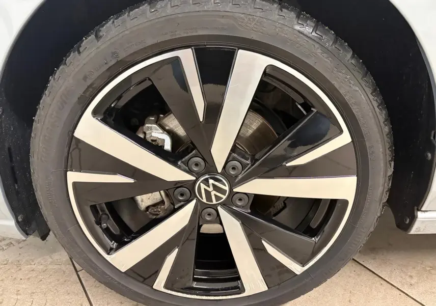 Gros plan sur la jante alliage 18 pouces 'Catania' bicolore noir et argent d'une Volkswagen Golf Argent Dolomite.